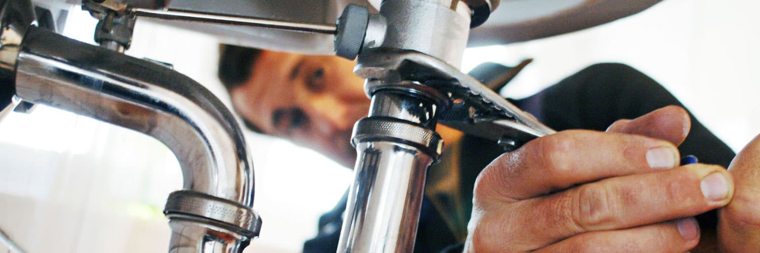 Photo of plumbing repair man fixing a pipe.